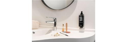 lavabo con espejo y secador de pelo negro en ibis Acheres St Germain en Laye, en Achères