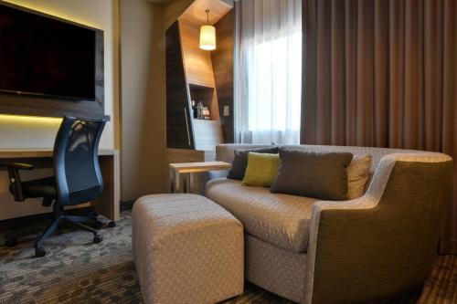 a living room with a couch and a desk at Courtyard by Marriott San Luis Potosi, Los Lagos in San Luis Potosí