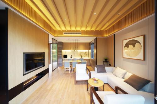 a living room with a couch and a tv at Yibo Jinling Hotel Moganshan in Huzhou