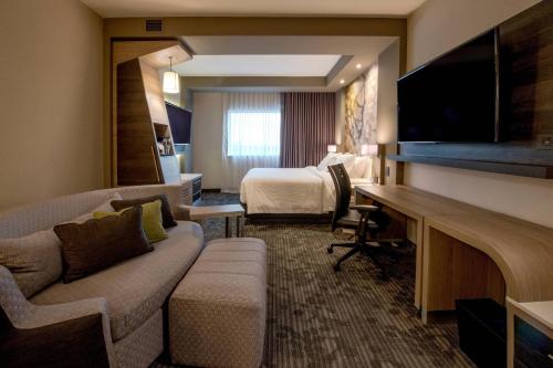 a hotel room with a couch and a bed at Courtyard by Marriott San Luis Potosi, Los Lagos in San Luis Potosí