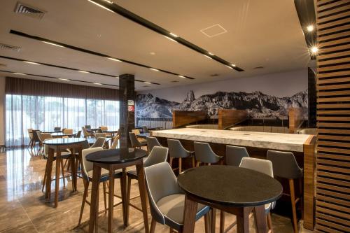 a restaurant with tables and chairs and a bar at Courtyard by Marriott San Luis Potosi, Los Lagos in San Luis Potosí