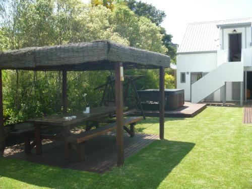 a picnic table under a pavilion in a yard at At Parkland Place B&B in Whitianga