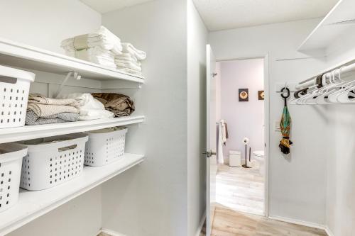 a white walk in closet with white baskets and towels at Waterfront Condo with Dock Access in Carlsbad! in Carlsbad