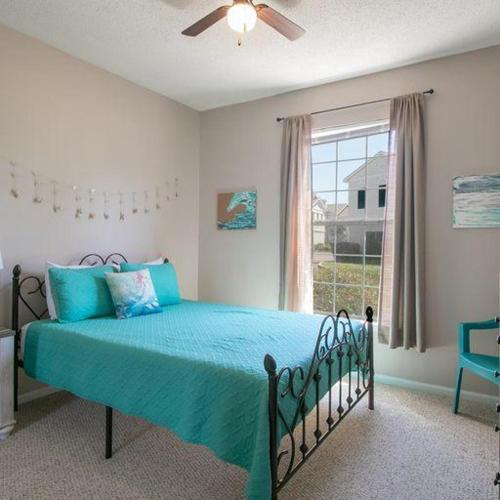 a bedroom with a bed with blue sheets and a window at Legacy Villa 1901 in Gulfport