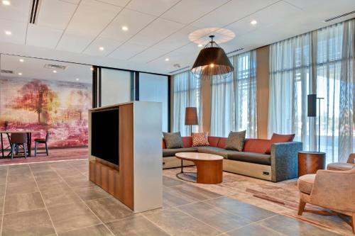 a living room with a couch and a tv at Courtyard by Marriott Bentonville Rogers Promenade in Rogers