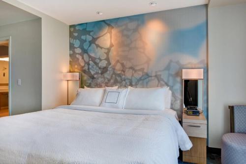 a bedroom with a white bed and a wall mural at Courtyard by Marriott Bentonville Rogers Promenade in Rogers