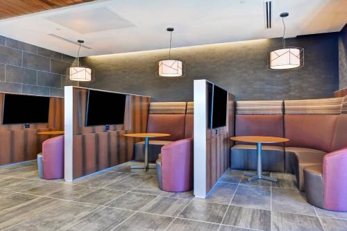 a bar with two tables and two televisions at Courtyard by Marriott Bentonville Rogers Promenade in Rogers