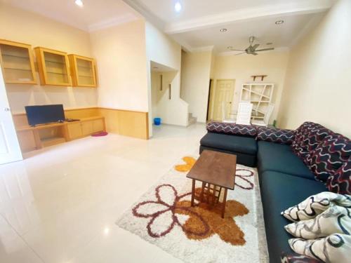 a living room with a blue couch and a table at KUDIMAN Homestay 2 in Kuala Terengganu