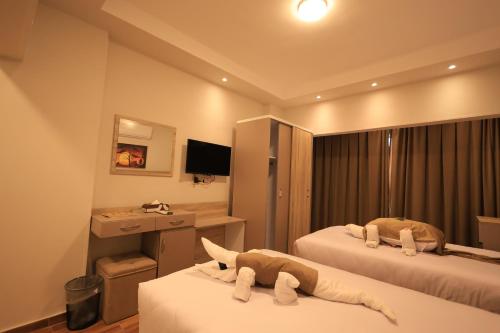 a hotel room with two beds with towels at Akhenaton Hotel in Al Minya