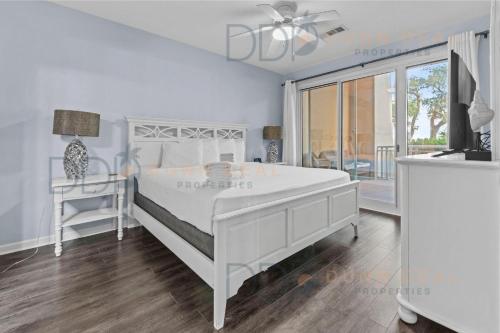 una camera da letto bianca con un letto bianco e una finestra di Legacy Tower Two 107 Deluxe a Gulfport