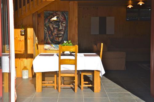 uma mesa e cadeiras com um quadro na parede em Barn Bed and Breakfast em Waitati