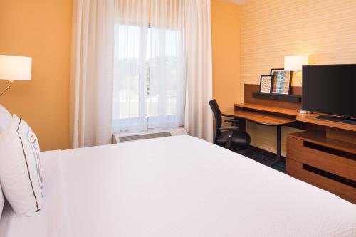 a hotel room with a bed and a desk with a computer at Fairfield Inn & Suites by Marriott Akron Stow in Stow