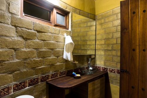 a bathroom with a sink and a brick wall at Chalets Sol Muisca RNT85322 in Villa de Leyva