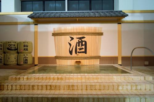 a fountain in a building with a sign on it at Hakone Kowakien Miyamafurin in Hakone