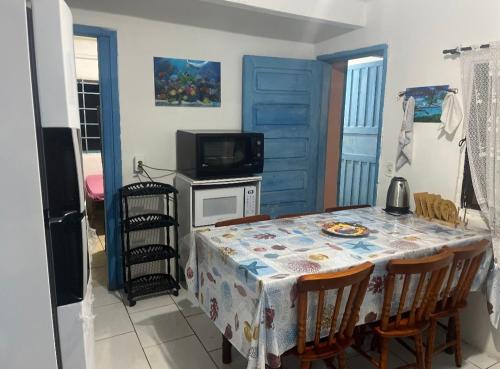 een eetkamer met een tafel met stoelen en een televisie bij casa de praia em Itapoá SC a uma quadra da praia in Itapoa