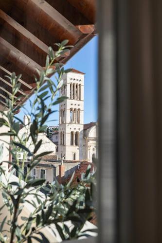 a building with a clock tower in the distance at Forkira Luxury Hvar in Hvar