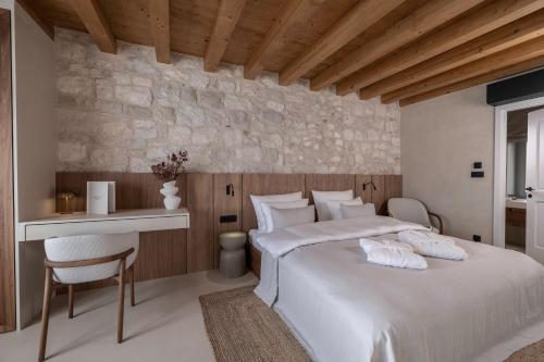 a bedroom with a large white bed and a desk at Forkira Luxury Hvar in Hvar