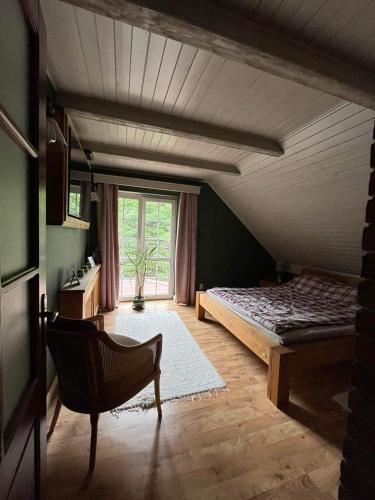 a bedroom with a bed and a chair in a room at Lawendowy Dom in Spychowo