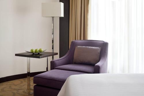 a bedroom with a purple chair and a bed at Courtyard by Marriott Riyadh Diplomatic Quarter in Riyadh