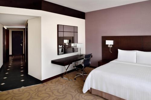 a hotel room with a bed and a desk at Courtyard by Marriott Riyadh Diplomatic Quarter in Riyadh
