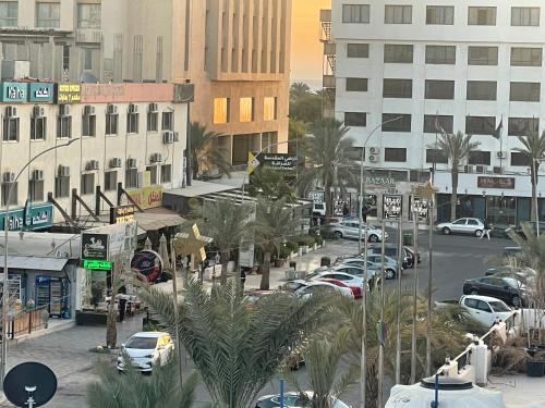 a city with cars parked in a parking lot at Pizza Street Hostel in Aqaba