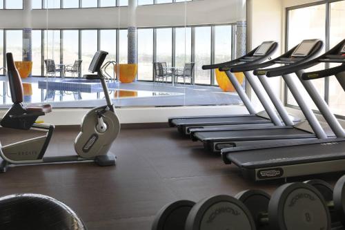 a gym with rows of cardio machines and a swimming pool at Courtyard by Marriott Riyadh Diplomatic Quarter in Riyadh