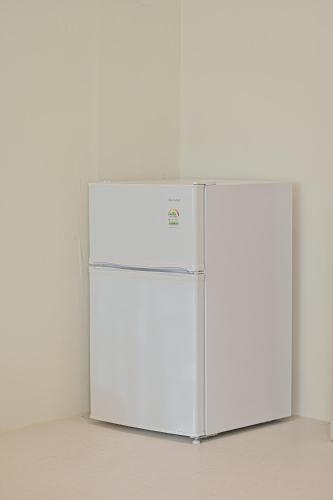 a white refrigerator in a room with a wall at In Stay Guesthouse in Seogwipo