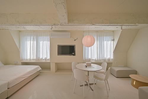 a bedroom with a bed and a table and chairs at In Stay Guesthouse in Seogwipo