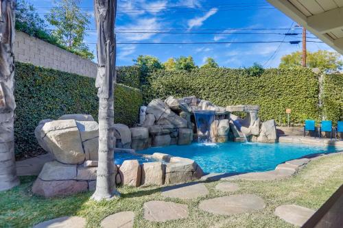 a pool in a backyard with a waterfall and rocks at Destination #48 in Placentia