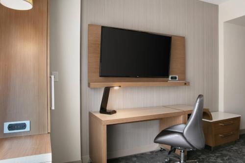 a room with a desk with a chair and a television at Courtyard Sioux City Downtown/Convention Center in Sioux City