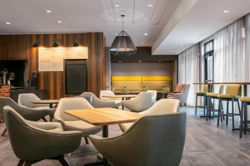 a restaurant with tables and chairs and a bar at Courtyard Sioux City Downtown/Convention Center in Sioux City