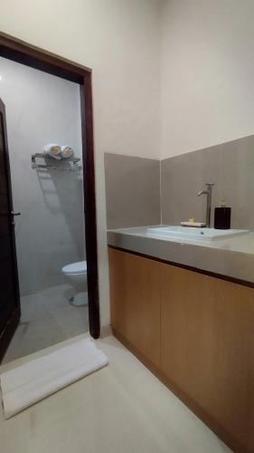 a bathroom with a tub and a sink and a toilet at Puri Rama Guest House Denpasar Bali in Kerobokan