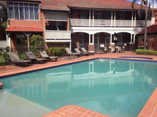 a swimming pool in front of a building at Mercure Maitland Monte Pio in Maitland