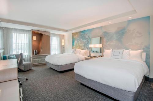 a large hotel room with two beds and a couch at Courtyard by Marriott Raleigh Cary/Parkside Town Commons in Cary