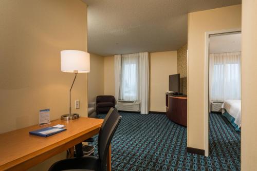 a hotel room with a desk and a bed at Fairfield Inn and Suites by Marriott Augusta in Augusta