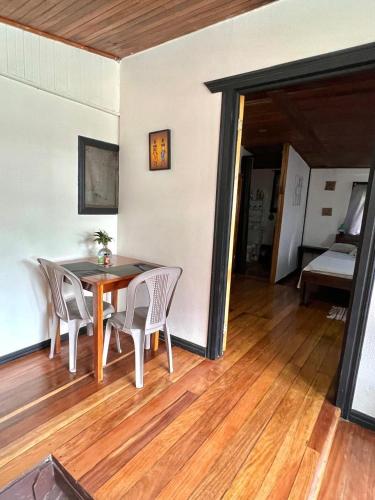 a dining room with a table and chairs on a wooden floor at Pura Vida Hostel in Montezuma