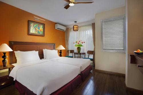 a bedroom with a large white bed and a window at Classic Street Hotel in Hanoi