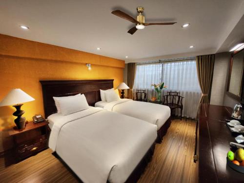 a bedroom with two beds and a ceiling fan at Classic Street Hotel in Hanoi