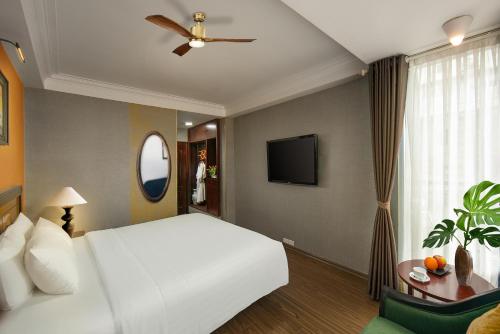 a bedroom with a white bed and a ceiling fan at Classic Street Hotel in Hanoi