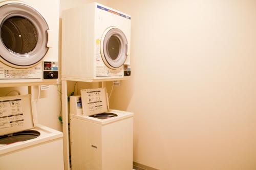 a laundry room with a washing machine and a washer at Hotel Nupka in Obihiro