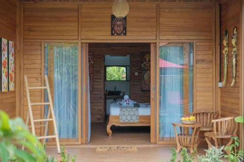 a porch of a wooden house with a couch and a table at Villa Felise Sanur in Sanur
