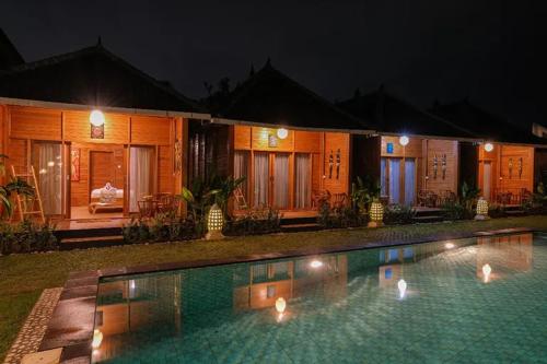 a resort with a swimming pool at night at Villa Felise Sanur in Sanur