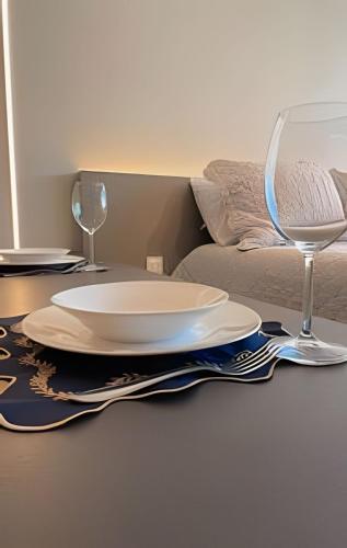 a table with two plates and wine glasses on it at Studio Luxo p/4 pessoas, a 50m do mar in Cabedelo