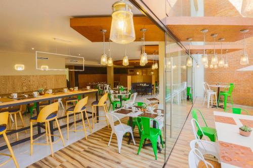 a restaurant with green and yellow chairs and tables at Courtyard Toluca Airport in Toluca