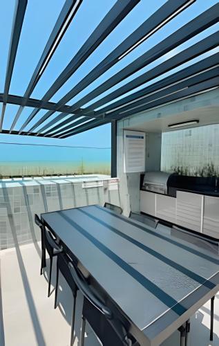 a table on a balcony with a view of the ocean at Studio Luxo p/4 pessoas, a 50m do mar in Cabedelo