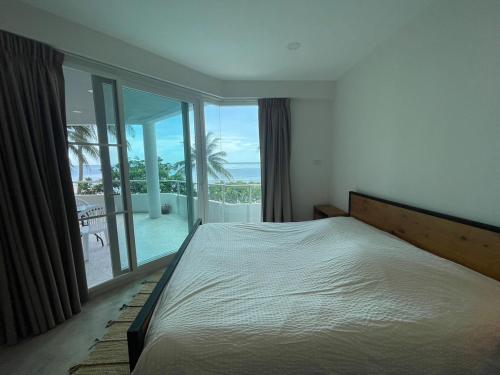 a bedroom with a bed and a view of the ocean at 2 Bedder Beach Front Condo in Prime Location in Hua Hin