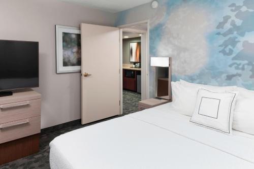 a bedroom with a large white bed and a flat screen tv at Courtyard Tuscaloosa in Tuscaloosa