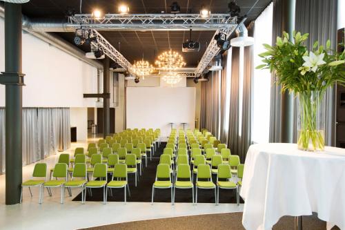 a conference room with green chairs and a table with a vase of flowers at Courtyard by Marriott Stockholm Kungsholmen in Stockholm