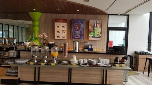 a bar in a restaurant with a counter with drinks on it at MaxOneHotels @Balikpapan in Balikpapan