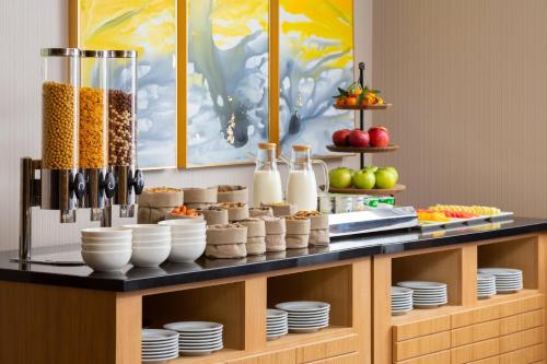 een buffet met kommen, borden en ander eten bij Courtyard by Marriott Tashkent in Tasjkent